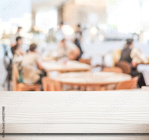 Empty white wood table and blurred cafe with bokeh light background, food and product display montage