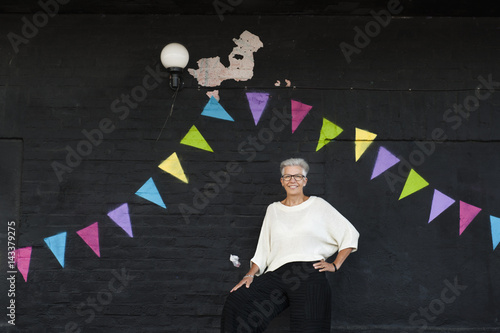 Sweden, Portrait of senior woman standing against wall photo