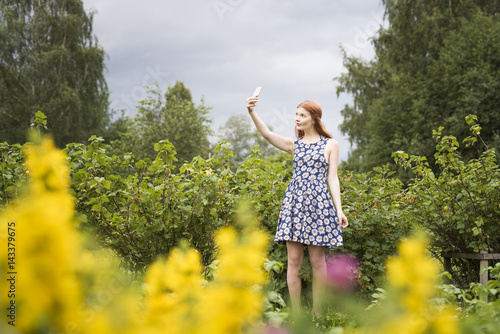 Finland, Pirkanmaa, Tampere, Woman taking selfie in rural scenery photo