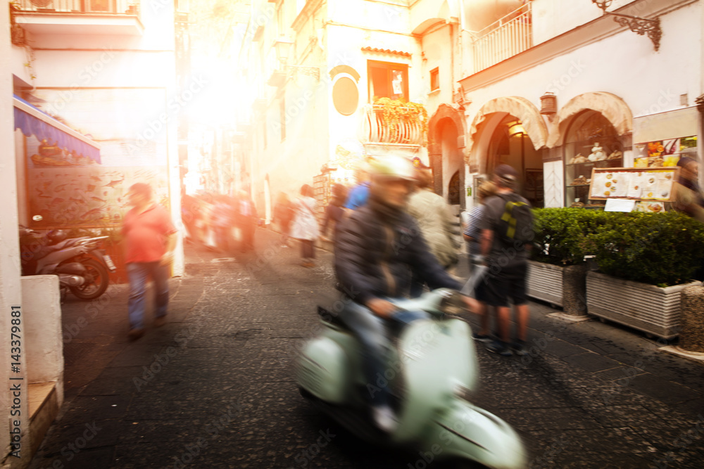 man riding scooter motorcycle in amalfi street south italy most popular traveling destination