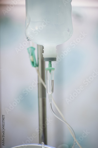 A bottle of saline is hung on the rail to pass through the hose for treating the patient.