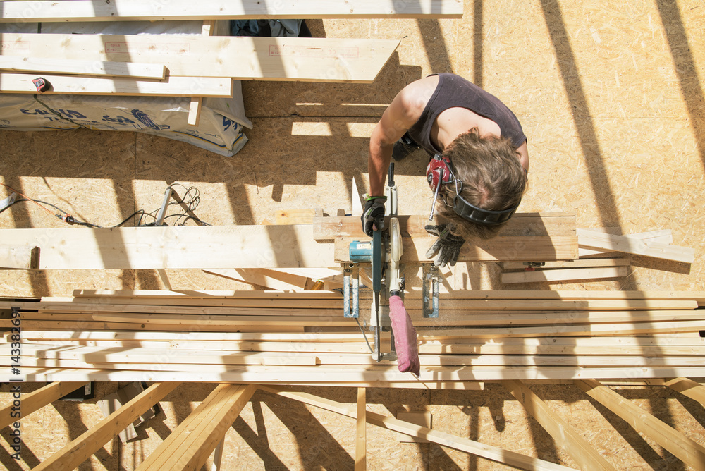 Sweden, Sodermanland, Overhead view of carpenter cutting wooden plank with circular saw Sweden, Sodermanland, Overhead view of carpenter cutting wooden plank with circular saw