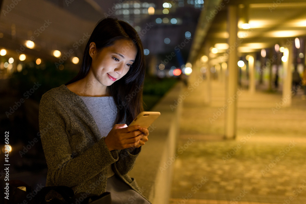 Woman working on cellphone in Hong Kong at night Woman working on cellphone in Hong Kong at night