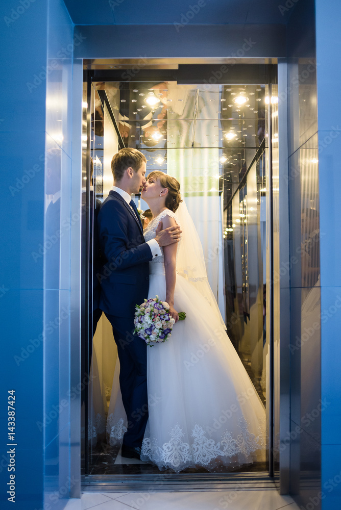 Groom and bride are kissing in hotel interior Groom and bride are kissing in hotel interior