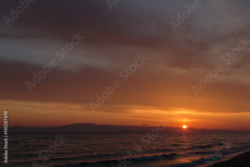 Spring orange dawn on the shore of the calm sea during the tide. © lenus-ss