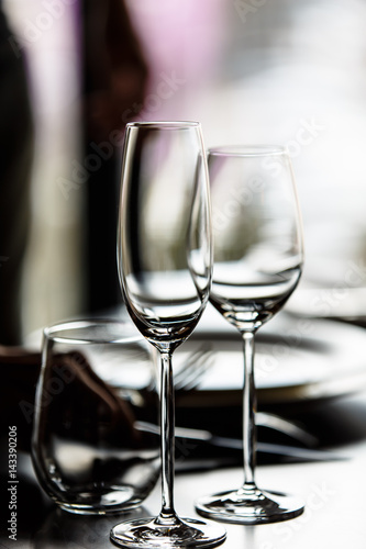 Empty glasses for champagne and wine are on the table in a row.