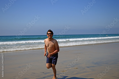 Happy tourist man jumping high on the beach and enjoying holiday in San Diego, California, USA © Ridvan