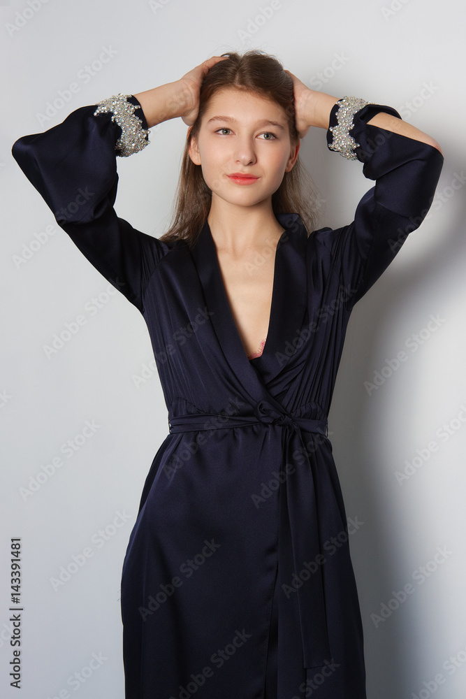 Attractive fashion model in long silk dress touching hair. Attractive fashion model in long silk dress touching hair.