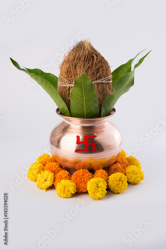 copper kalash with coconut and mango leaf with floral decoration. essential in hindu puja, front view, closeup