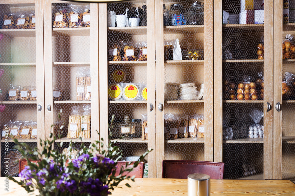 Interior of cafe with sweet stuff in cupboards