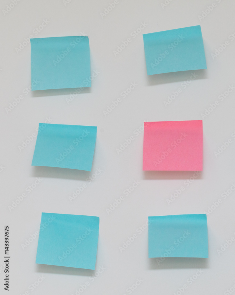 Single pink post it note in sea of blue post it notes Single pink post it note in sea of blue post it notes