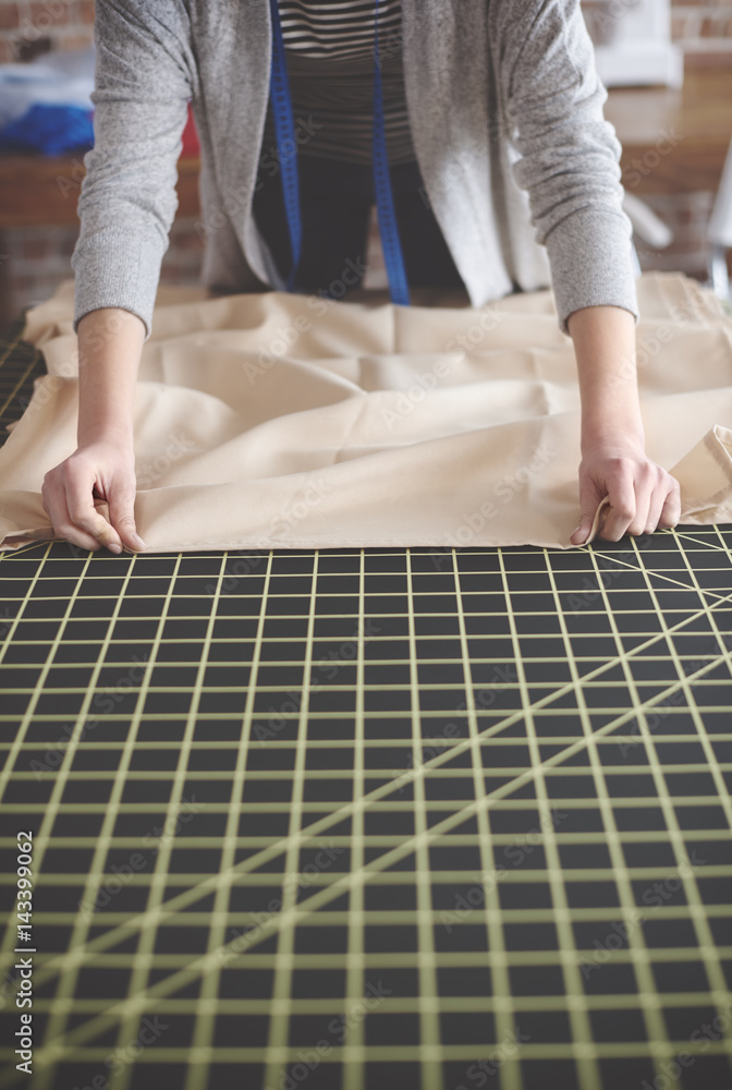 Tailor measuring fabric on the table .