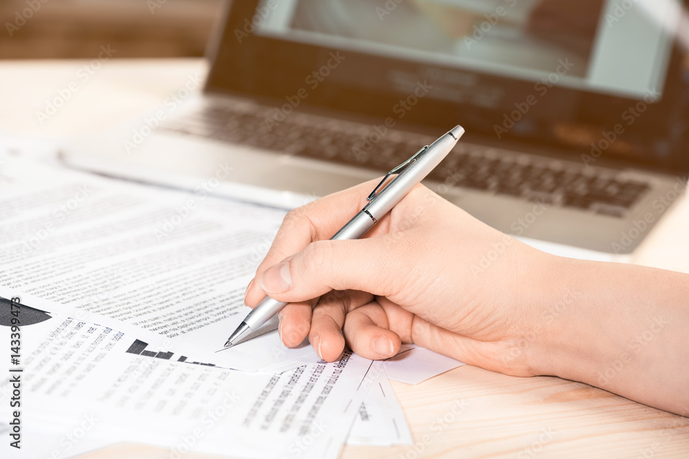 cropped view of businesswoman signing contract documents sitting at table cropped view of businesswoman signing contract documents sitting at table