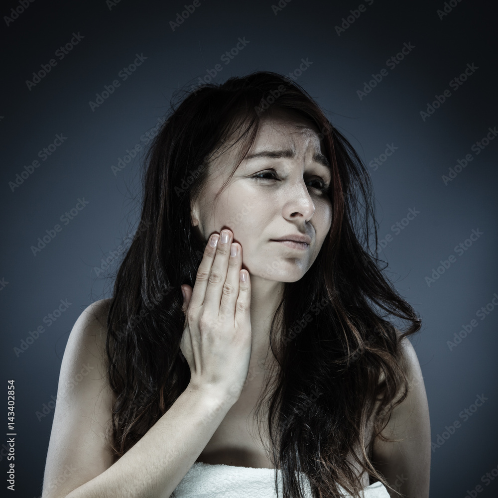 Woman massaging her jaw Woman massaging her jaw