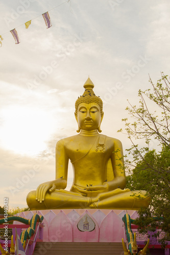 Big Golden Buddha statue over scenic white and blue sky at Wat Sai Dong Yang Temple. Phichit  Thailand.