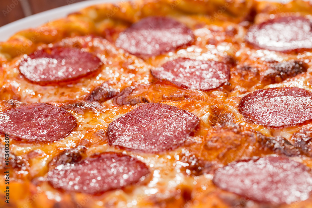 Top view of pizza with salami on a wooden background Top view of pizza with salami on a wooden background