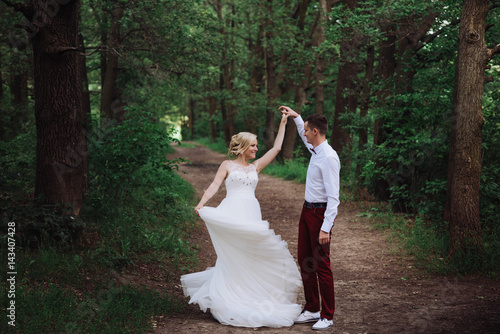 Happy and young bride and groom dancing on nature, dance pose on wedding day,wedding dance in the open air. Dancers love flying.
