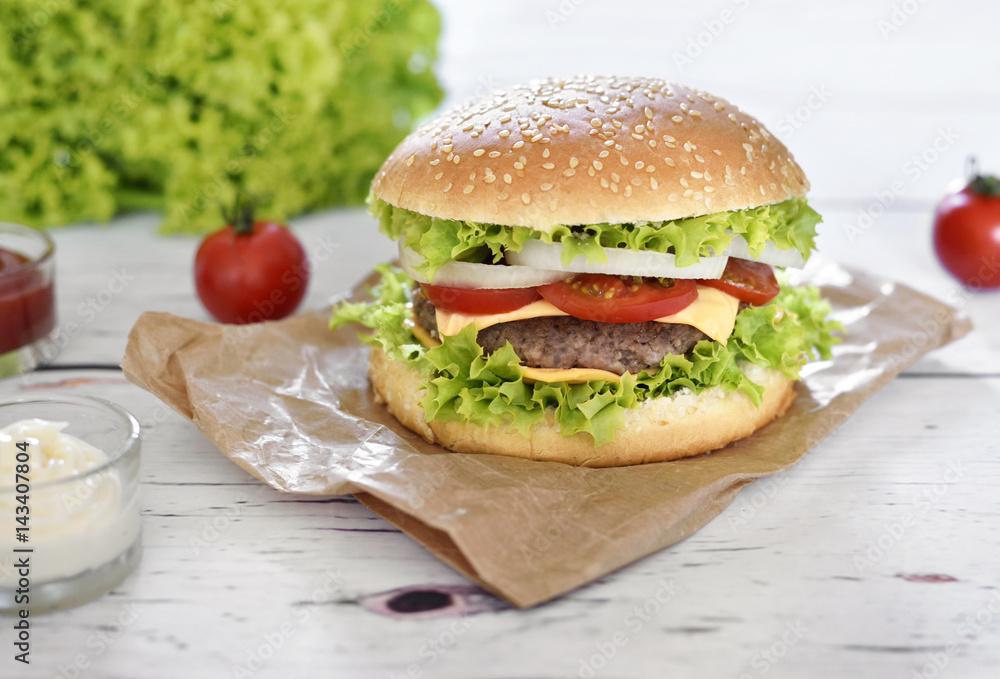 Fresh, delicious burger or cheeseburger with sauces and fresh ingredients. Hamburger on a white table. Fresh, delicious burger or cheeseburger with sauces and fresh ingredients. Hamburger on a white table.