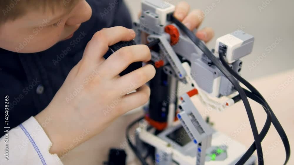 School boy at engineering classroom making robot. Robotechnics education. 4K. School boy at engineering classroom making robot. Robotechnics education. 4K.