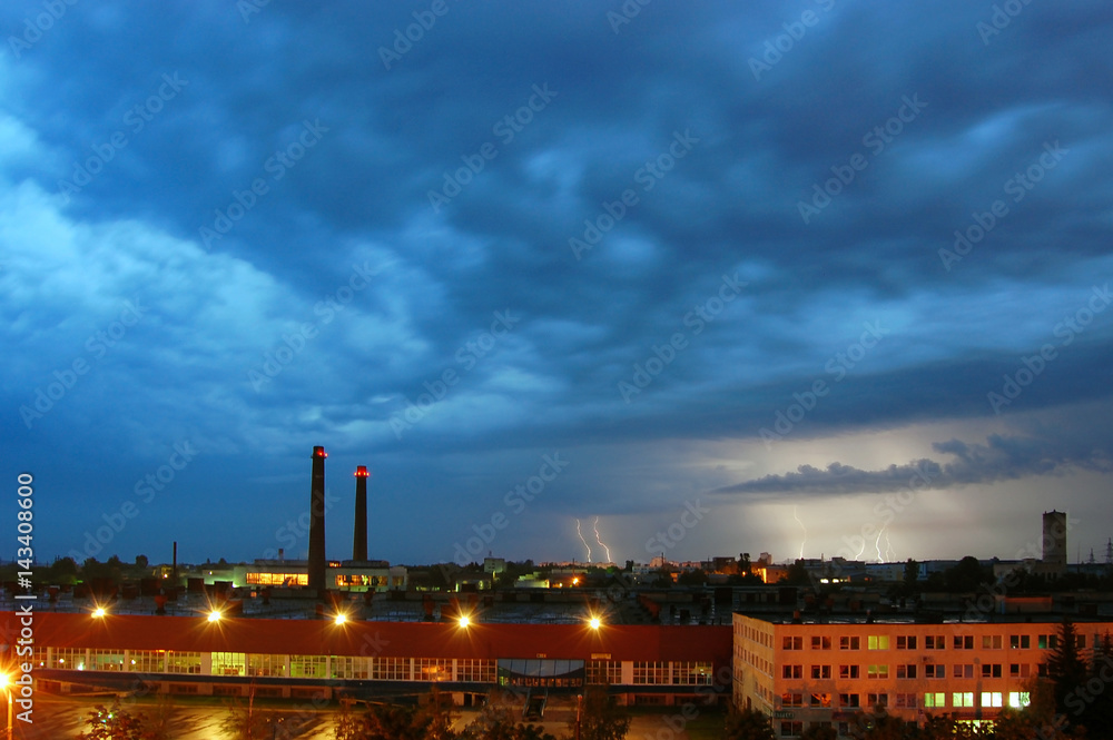 Aerial view of industrial plant at night during a thunderstorm with lightning.