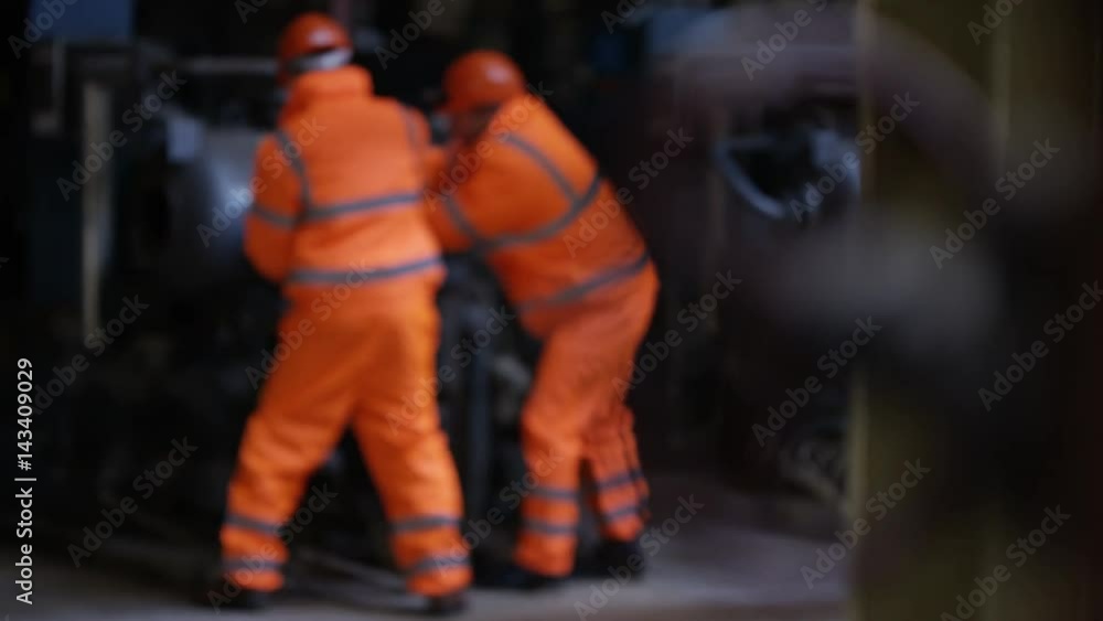 Engineers in power station carrying out maintenance & checking the machinery Engineers in power station carrying out maintenance & checking the machinery