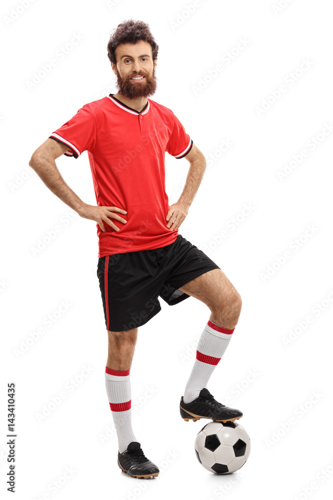 Guy in red jersey pressing a football with his foot