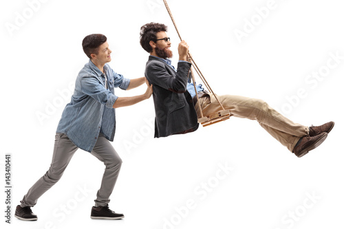Tableau sur toile Son pushing his father on a swing