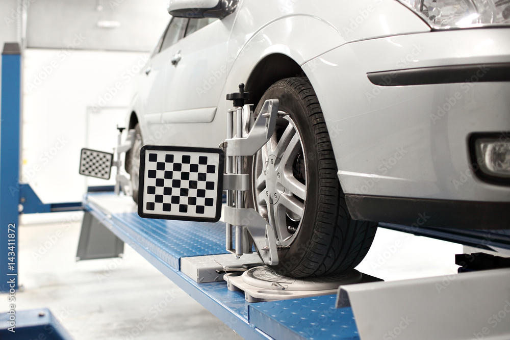 Fototapeta premium Grid sensor sets mechanic on auto. Car stand with sensors wheels for alignment camber check in workshop of Service station.