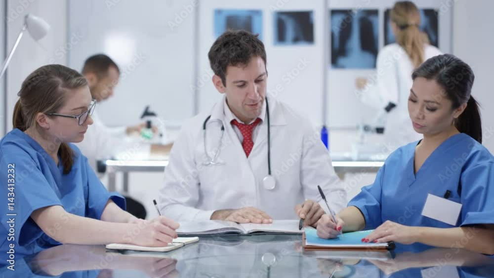 Medical team in a meeting with colleagues working in background Medical team in a meeting with colleagues working in background