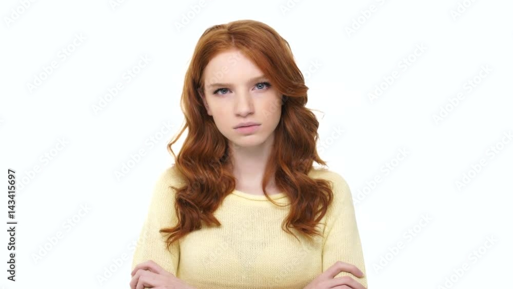 Angry aggressive girl with red hair standing with arms folded and saying I Hate You phrase over white Angry aggressive girl with red hair standing with arms folded and saying I Hate You phrase over white