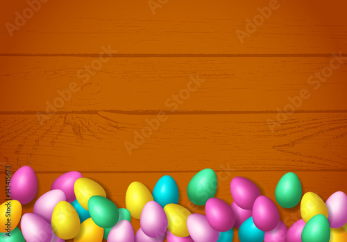 Easter frame with shiny colorful happy eggs spread over wooden background