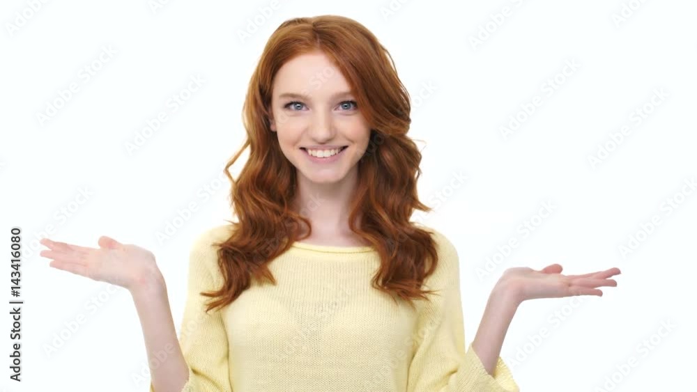 Smiling excited young girl with long curly red hair holding copy space on two palms isolated over white Smiling excited young girl with long curly red hair holding copy space on two palms isolated over white