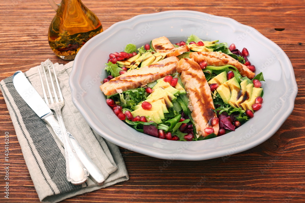 Salad with fried salmon, avocado and pomegranate seeds Salad with fried salmon, avocado and pomegranate seeds