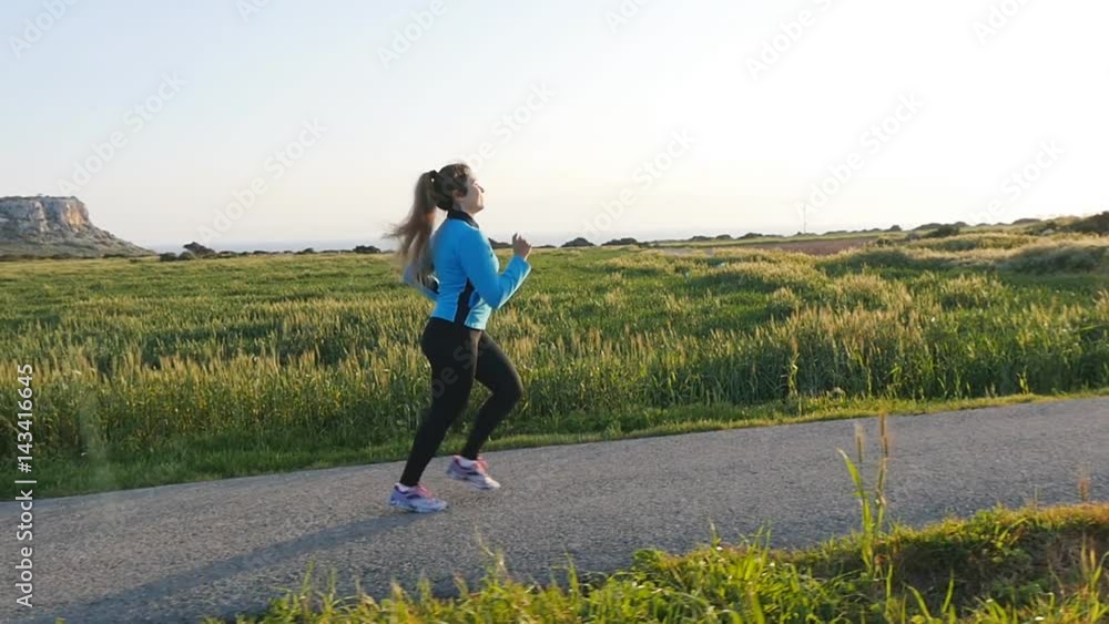 Young woman runner running on sunrise road. Fitness concept Young woman runner running on sunrise road. Fitness concept