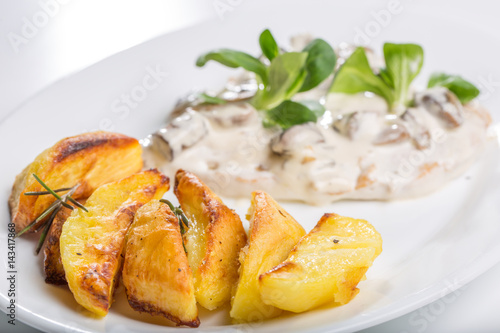 Tasty grilled chicken with mushroom sauce and baked potatoes