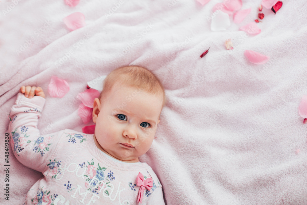 Adorable two month old baby girl lying on the pillow and looking into the camera Adorable two month old baby girl lying on the pillow and looking into the camera