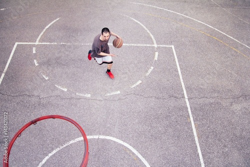 Fototapeta Naklejka Na Ścianę i Meble -  Basketball player outdoor practicing. Street ball.