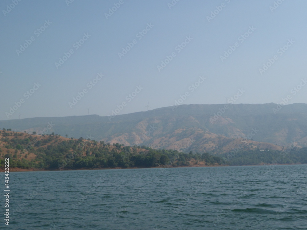 Fototapeta premium view of lake and hill with blue background