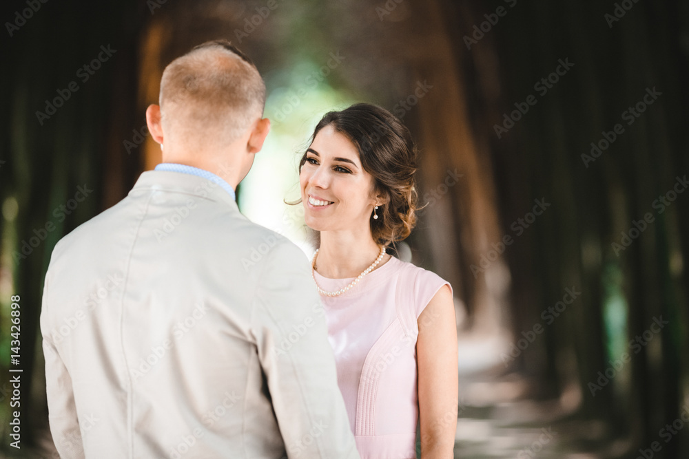 Look from behind groom's shoulder at cheerful brdie smiling to him Look from behind groom's shoulder at cheerful brdie smiling to him