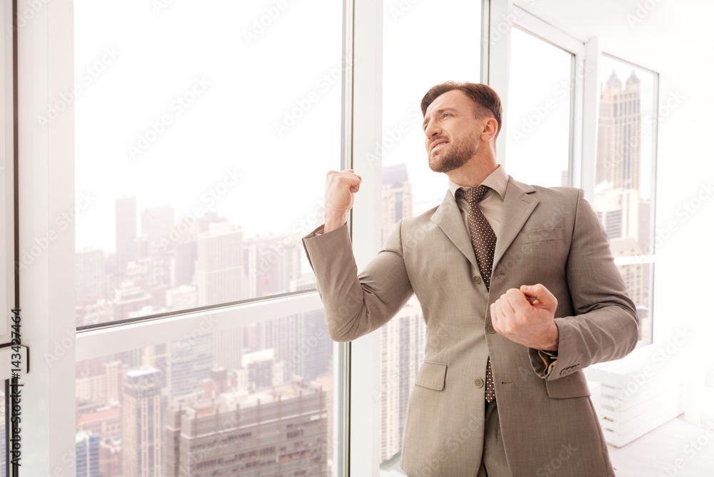 Successful businessman standing near office window Successful businessman standing near office window