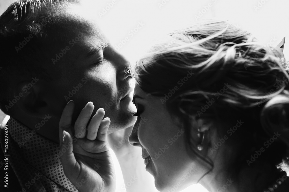 Tender touches of lovely man and woman sitting before bright window Tender touches of lovely man and woman sitting before bright window