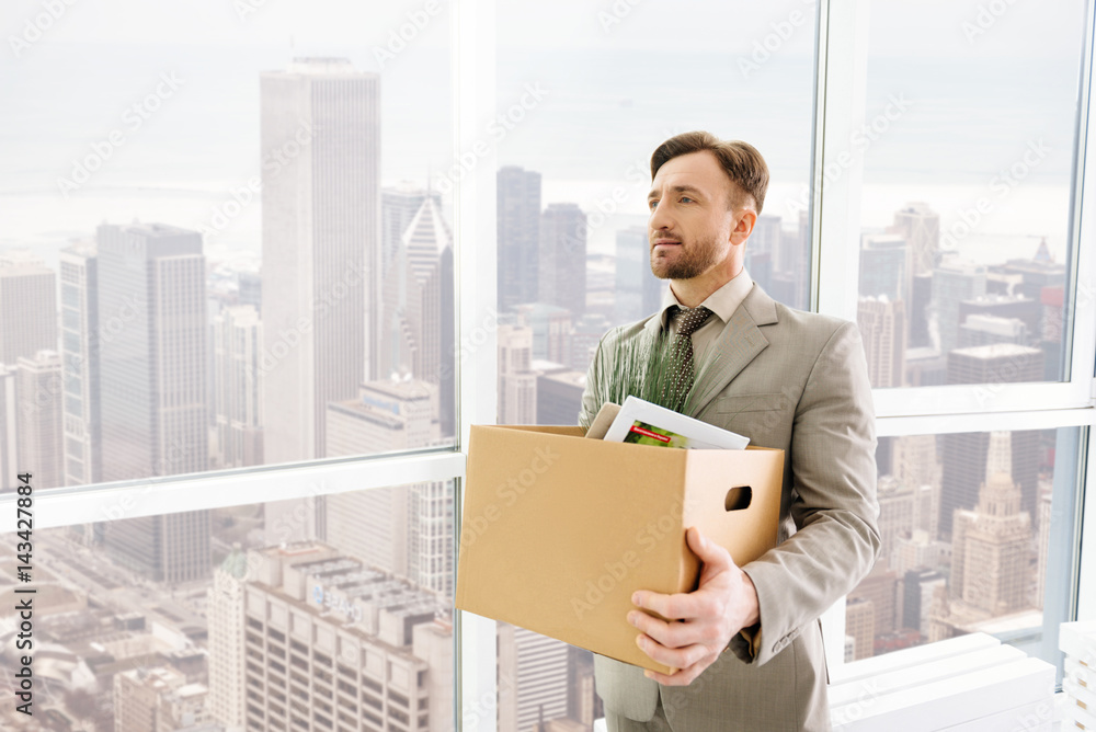 Pleasant serious employee standing in the office