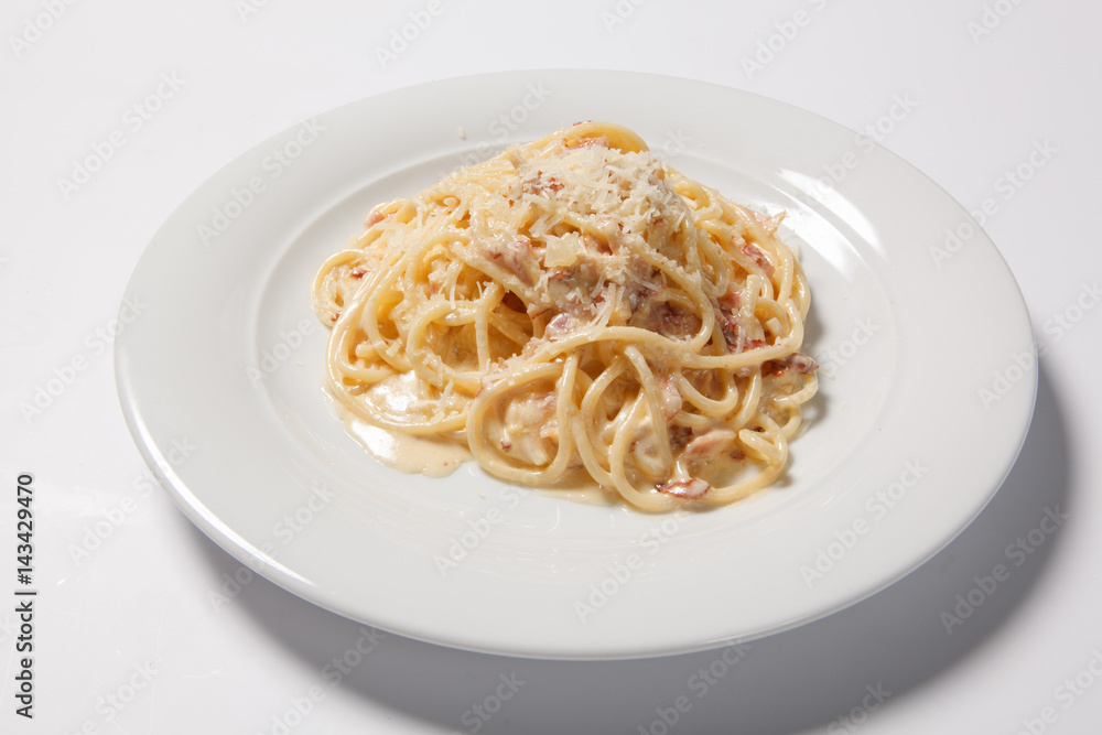Spaghetti Carbonara with bacon and cheese on a white plate