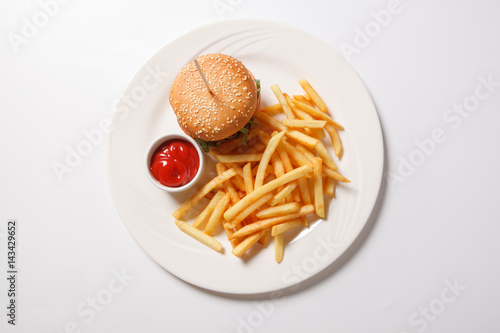 Fast food hamburger and french fries on a white plate