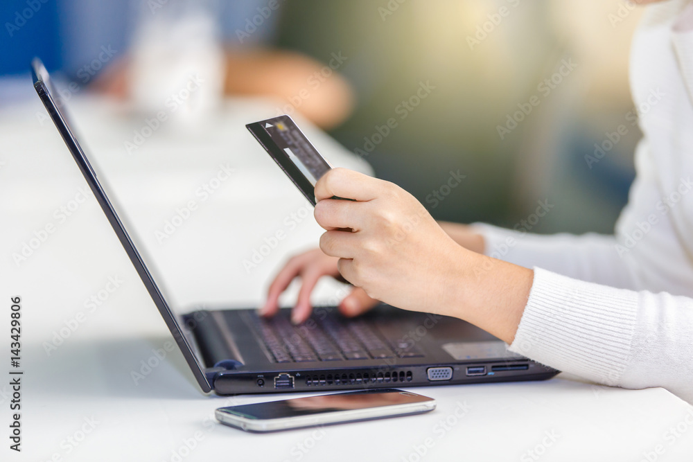 Fototapeta premium Hands holding credit card and using laptop. Online shopping