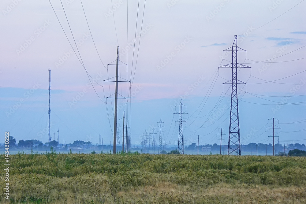 Pylon and transmission power line in fog sunset
