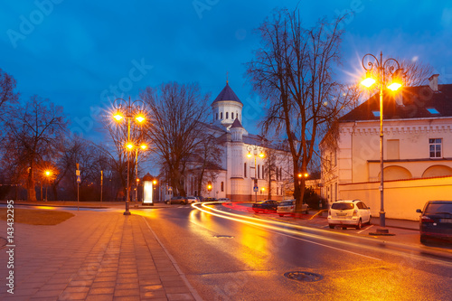 Picturesque Street and luminous track from the car at night in Old Town of Vilnius, Lithuania, Baltic states. Our Lady of the Assumption Orthodox Cathedral on the background. © Kavalenkava