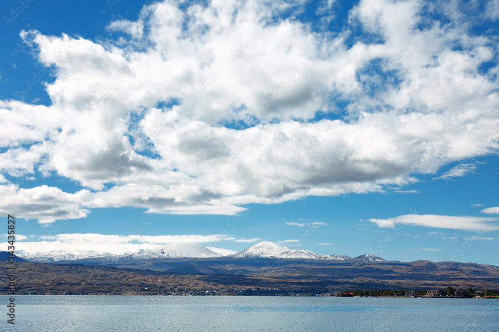 Fotografie Sevan lake and white clouds blue sky on a sunny day, Armenia
