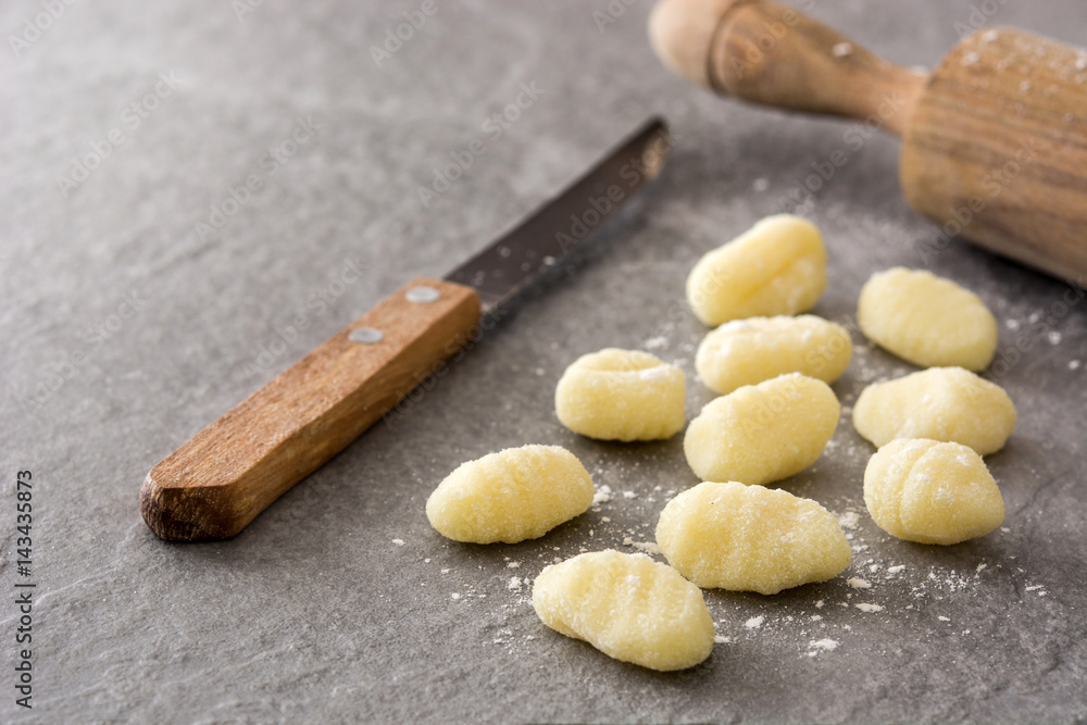 Raw gnocchi on gray stone background.
Raw gnocchi on gray stone background.