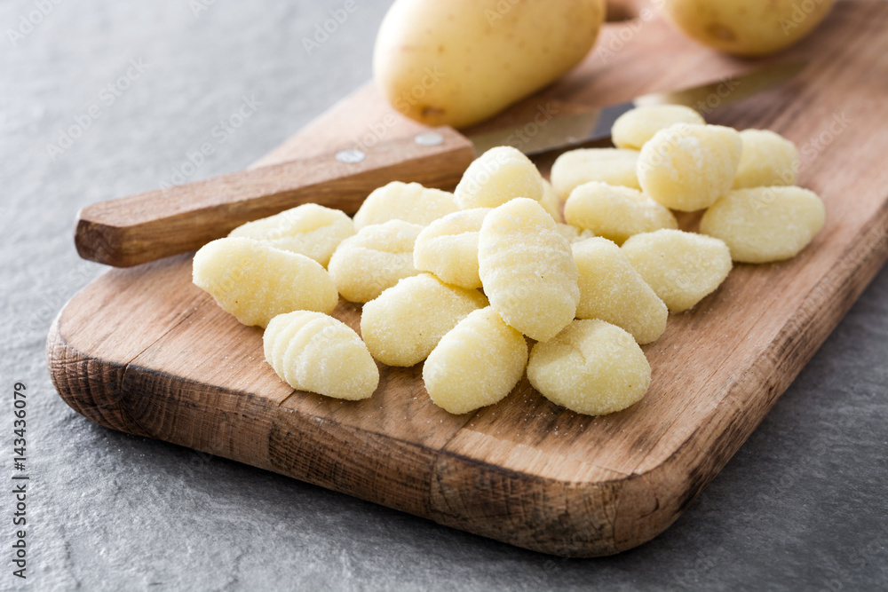 Raw gnocchi on gray stone background.
Raw gnocchi on gray stone background.